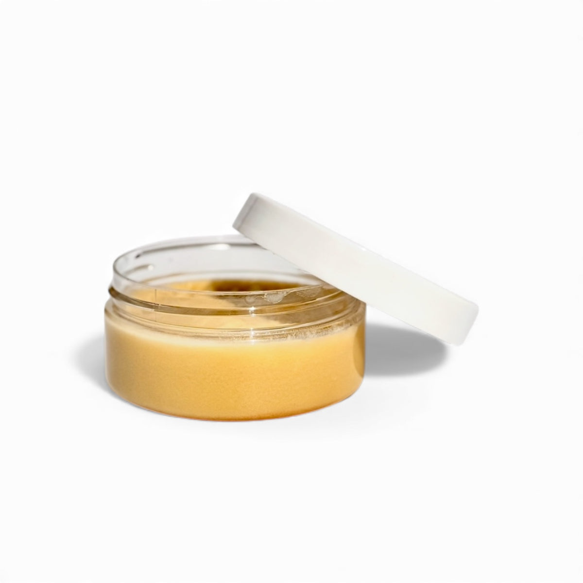 Jar of cbd muscle balm with a white lid on a white background